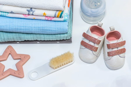 Baby girl pink shoes with other newborn baby accessories on white surface. Baby conceptの写真素材