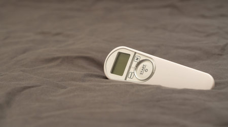 Non-contact thermometer on a brown background close-up