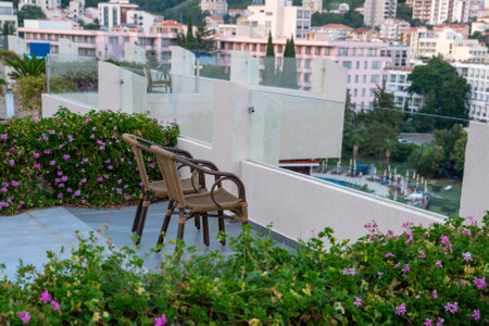 A pair of wicker chairs on the balcony of a modern hotel and with a beautiful view of the southern cityの写真素材