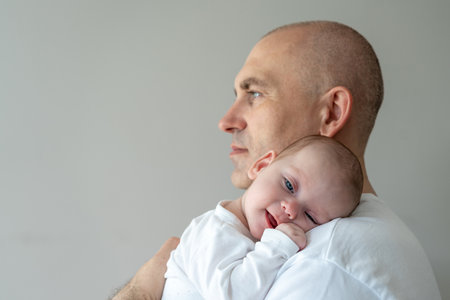 Father holds a baby in his arms. Parental care concept.の写真素材