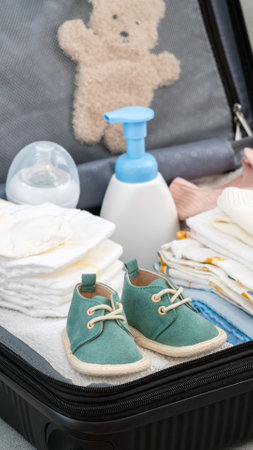 Suitcase full of baby clothes prepared for maternity hospital. Concept of getting ready for giving birthの写真素材