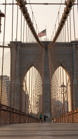 New York City, United States - September 18, 2022. People walk under the arch of the Brooklyn Bridge early in the morningのeditorial素材