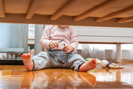 Baby with pacifier in mouth playing with sunglasses view from under cribの写真素材
