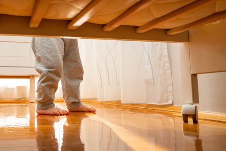 Baby walking barefoot to a crib photographed from the floor. Hidden frame conceptの写真素材