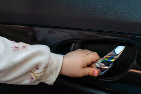 Dangerous action A childs hand reaches out to open a car doorの写真素材