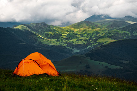Camping tent high in the mountains. Hiking tour or wild camping and travel conceptの写真素材