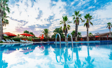 Clear water of a luxurious swimming pool with reflection of blue cloudy skyの写真素材