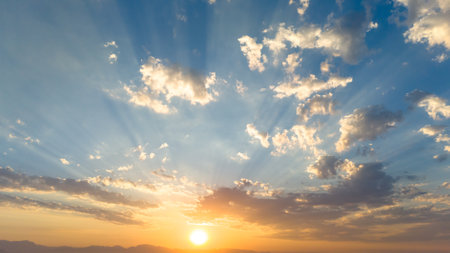 Beautiful sky with bright sun and clouds at sunset with sun beams as a backgroundの写真素材