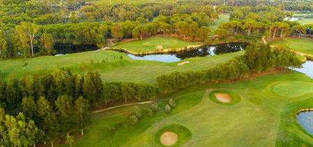 Panorama of golf course at sunset. Scenic panoramic view of golf fairway. Golf field with beautiful pinesの写真素材