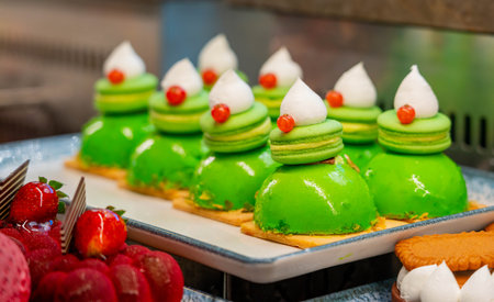 Macarons on sponge cake covered with green icing and whipped creamの写真素材