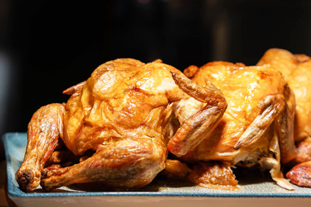 Several beautifully grilled chickens with a golden crustの写真素材