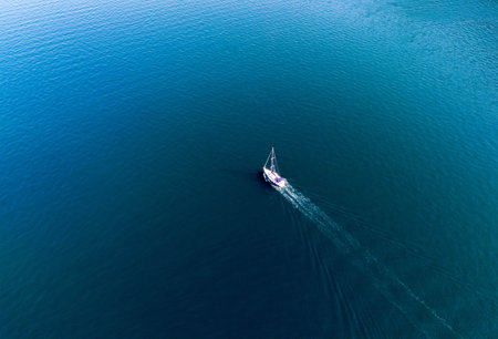 Yacht sailing on the sea without a sail on the motor. View from a drone