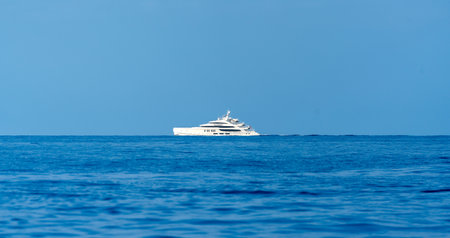 Snow-white modern fast sailing yacht against the background of blue sea and blue skyの写真素材