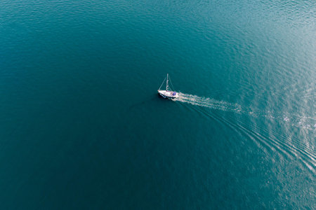 Turquoise sea crossed by a yacht going at full speed. Aerial viewの写真素材