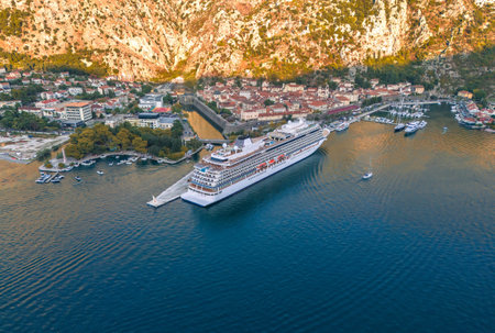Majestic Cruise Ship Docked in a Picturesque Harbor Surrounded by Mountainsの写真素材