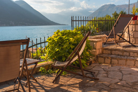 A seafront terrace with a couple of sun loungers in soft evening lightの写真素材