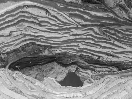 Monochrome panorama of a coal quarry with multi-level roads for trucks