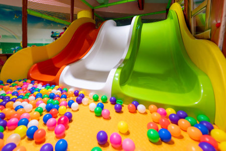 A colorful indoor playground with slides and a vibrant ball pit for kids.の写真素材