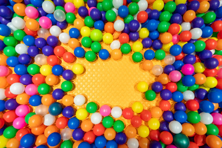 A bright and cheerful ball pit filled with colorful plastic spheres.の写真素材