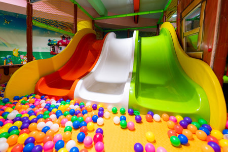 A cA bright and playful indoor play area with colorful slides and a ball pit.の写真素材