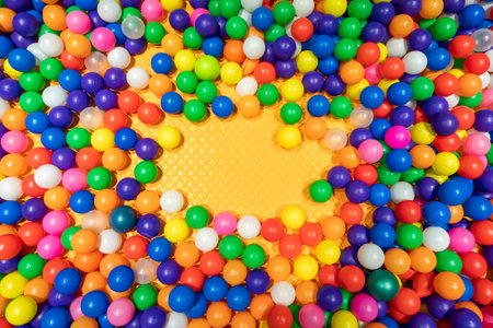 A vibrant and dynamic ball pit filled with colorful plastic balls for children.の写真素材