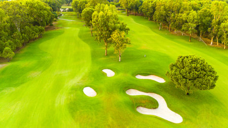 An aerial view of a pristine golf course with sand traps and lush greeneryの写真素材