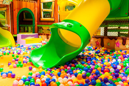 A colorful indoor playground with vibrant slides and a cheerful ball pit for kids.