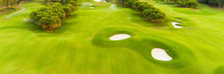 A panoramic view of a golf course with sand traps and lush greeneryの写真素材