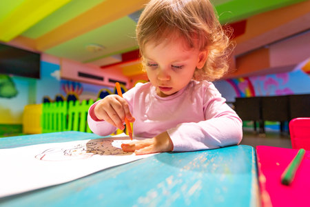 A curious child developing artistic skills in a vibrant and playful environment.の写真素材