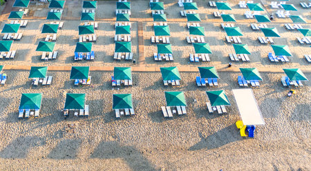 Aerial view of a well-organized beach resort with rows of umbrellas and lounge chairs.の写真素材