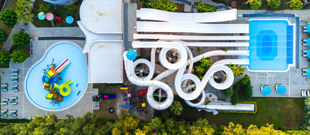 Aerial view of a water park with twisting slides, pools, and a family-friendly play areaの写真素材