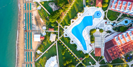 Aerial view of a beachfront luxury resort with pools, gardens, and a private beachの写真素材