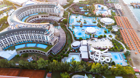 Aerial view of a beachfront luxury resort with modern architecture, pools, and a water parkの写真素材