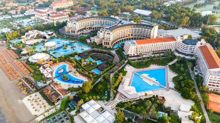 Aerial view of a luxury beachfront resort with grand pools, lush gardens, and private beach accessの写真素材