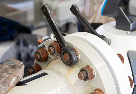 Close-up of an industrial flange with bolted connection and valve control levers ensuring precision and durabilityの写真素材