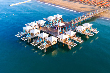 Aerial view of a luxury beach resort with exclusive overwater cabanas on a wooden pier.の写真素材
