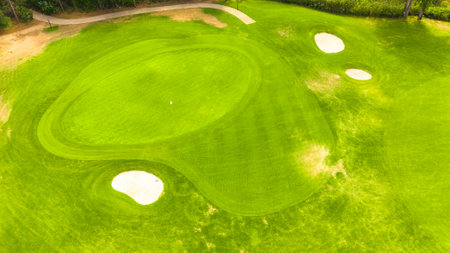 Aerial view of a golf course with sand traps and a well-maintained green fairwayの写真素材
