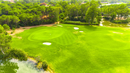 Aerial view of a golf course with sand traps, a pond, and lush greeneryの写真素材