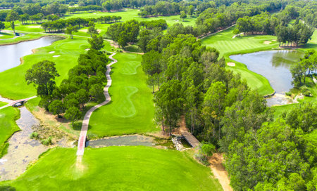 Aerial view of a golf course with trees, ponds, and winding pathsの写真素材