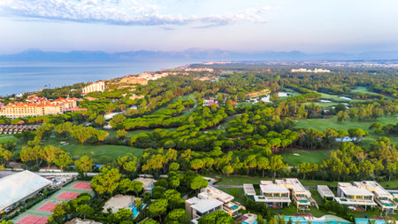 Aerial panoramic view of a seaside golf resort with luxury villas, hotels, and mountain sceneryの写真素材