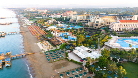 Aerial view of a luxury beachfront resort with pools, private piers, and lush tropical landscapesの写真素材