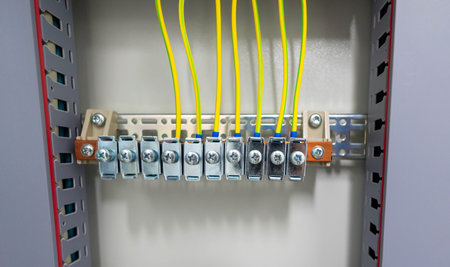 Grounding terminal block with connected yellow wires inside an industrial electrical panelの写真素材