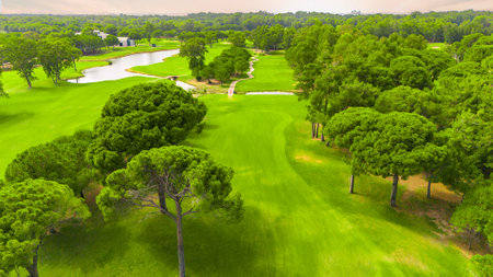 Aerial view of a golf course with a winding river, lush greenery, and manicured fairwaysの写真素材