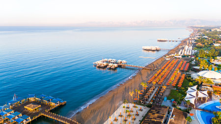 Aerial view of a beachfront luxury resort with private piers, sunbeds, and a scenic coastlineの写真素材