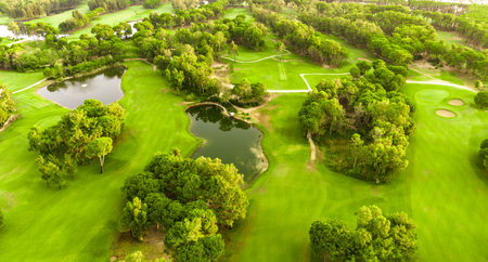 Aerial view of a golf course with lakes, sand bunkers, and tree-lined fairwaysの写真素材