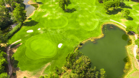 Aerial view of a golf course with putting greens, sand bunkers, and a water hazardの写真素材