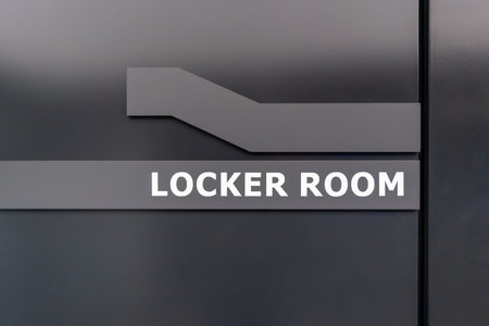 Modern locker room sign on a dark door in a sports or fitness facility