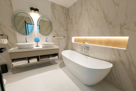 A modern elegant hotel bathroom with freestanding bathtub, double sink and round mirrorsの写真素材