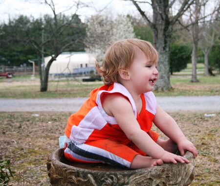 Baby boy playing in the birdbathの写真素材