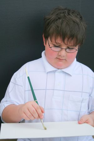Young boy painting a pictureの写真素材